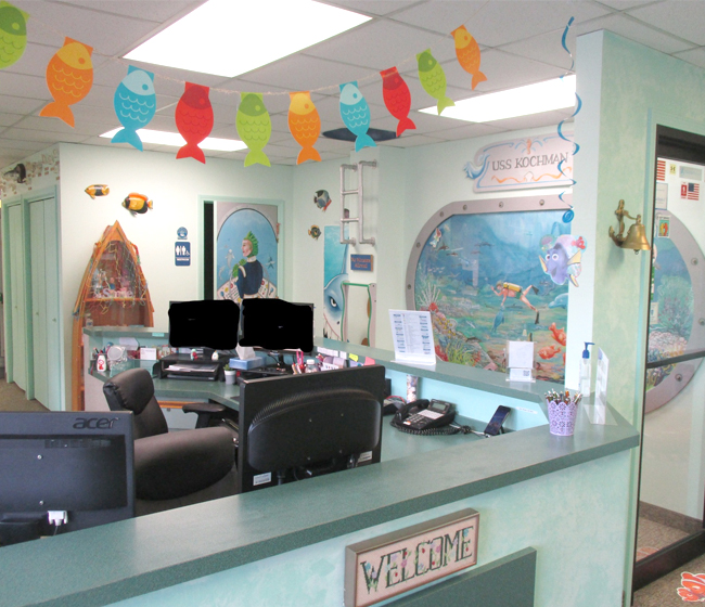 Pediatric dental office reception area with colorful decorations and aquarium-themed waiting room.